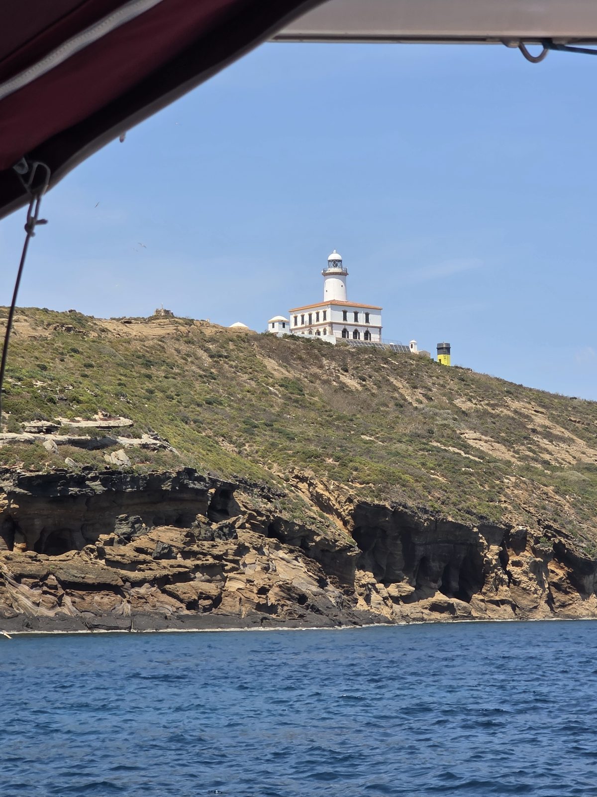 El faro de la Illa Grossa sobre los acantilados volcánicos